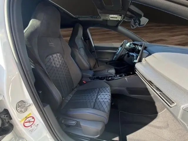 Vue intérieure côté conducteur de la Volkswagen Golf 2.0 TDI blanche, sièges sport R-Line et toit panoramique visible.