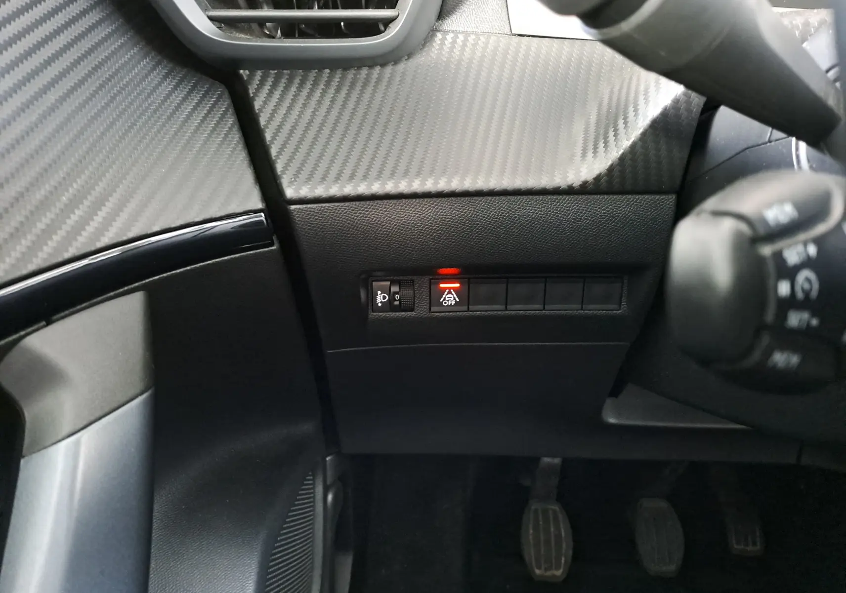 Détail intérieur côté gauche du tableau de bord d'une Peugeot 2008 2020 avec bouton d'arrêt du système start-stop allumé en rouge.