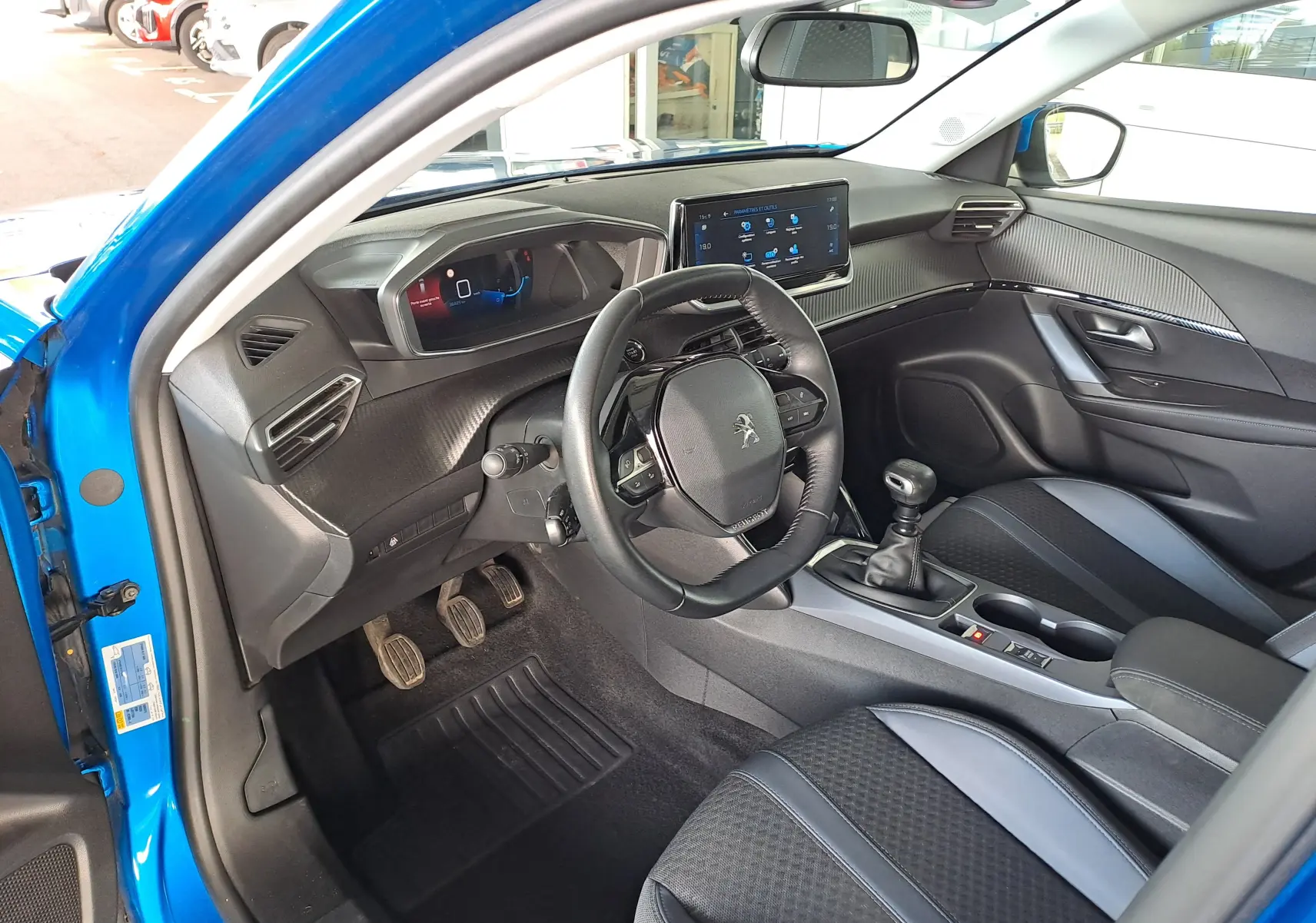Vue intérieure côté conducteur du Peugeot 2008 bleu Vertigo 2020, avec tableau de bord numérique et volant compact multifonction.