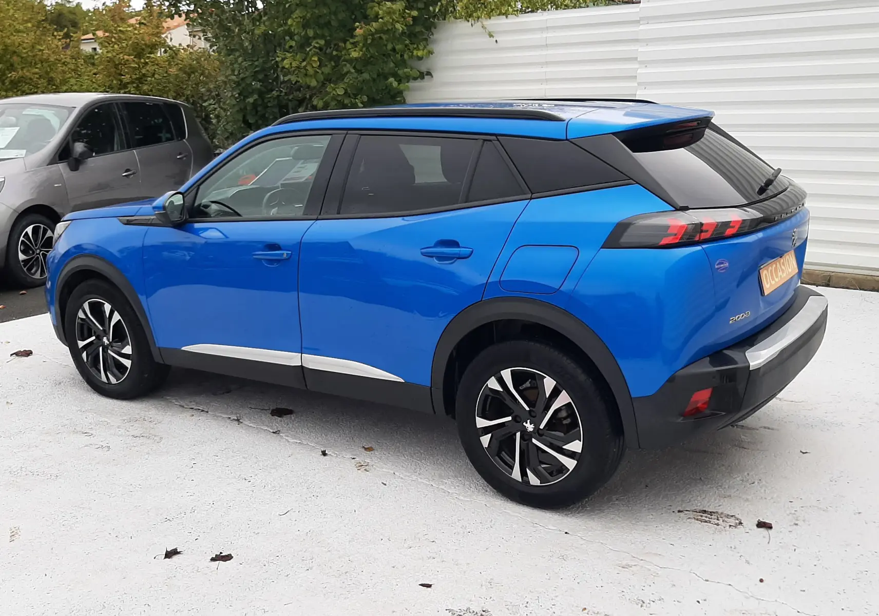 Peugeot 2008 bleu Vertigo vue de profil côté gauche, avec toit noir et jantes alliage noires.