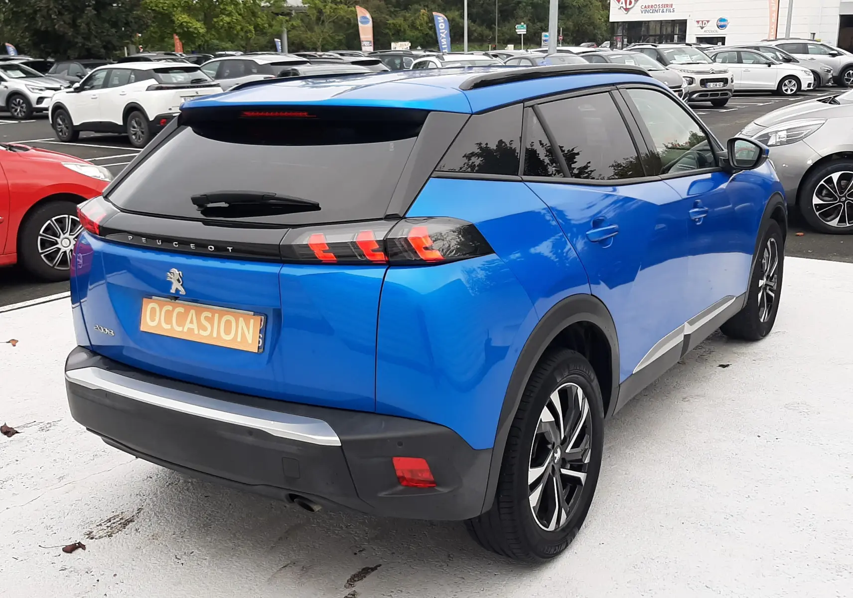 Vue 3/4 arrière droite d'un Peugeot 2008 bleu Vertigo 2020 avec feux arrière à griffes et toit noir contrasté.