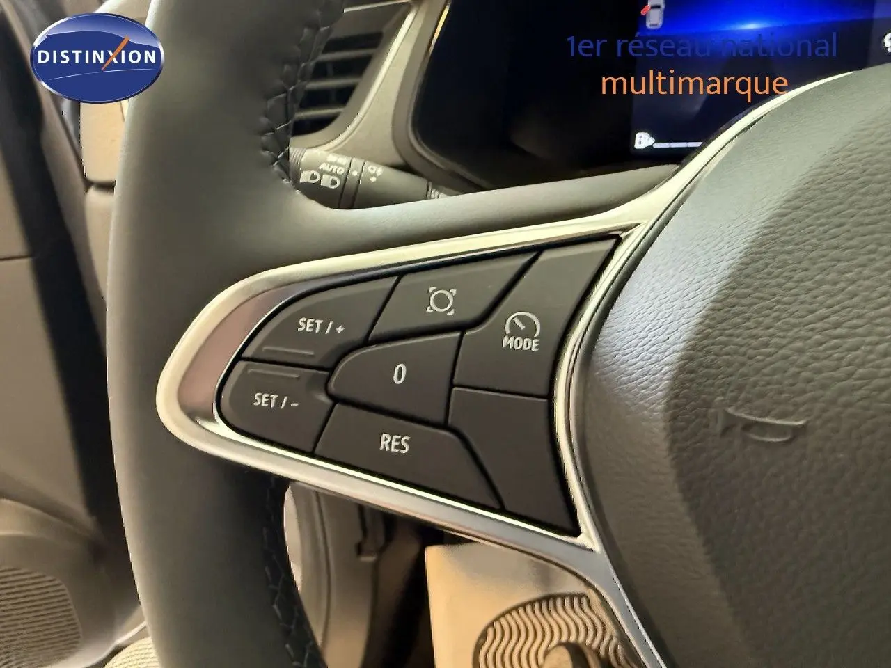 Gros plan sur les commandes du volant du Renault Captur gris cassiopée, mettant en valeur les boutons de régulateur de vitesse.