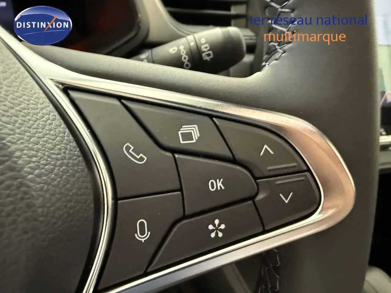 Gros plan sur les commandes multifonctions noires du volant du Renault Captur gris Cassiopée Métal 2025.