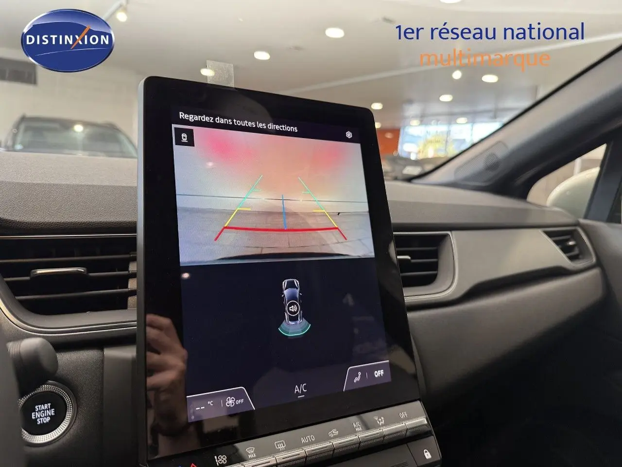 Vue intérieure du tableau de bord du Renault Captur 2025, écran tactile affichant la caméra de recul et les commandes climatisation.