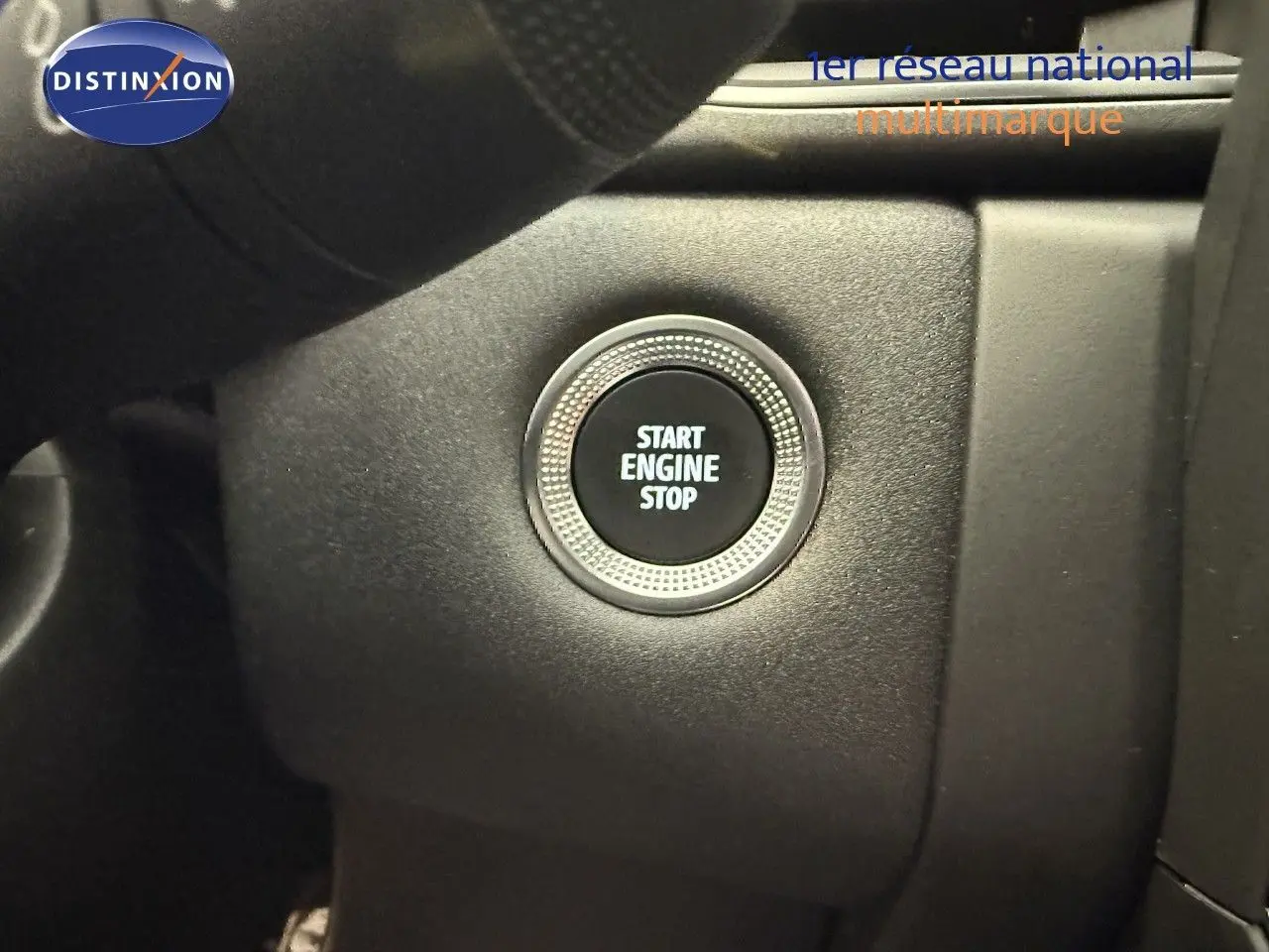 Bouton Start Engine Stop en gros plan sur le tableau de bord du Renault Captur gris Cassiopée 2025.