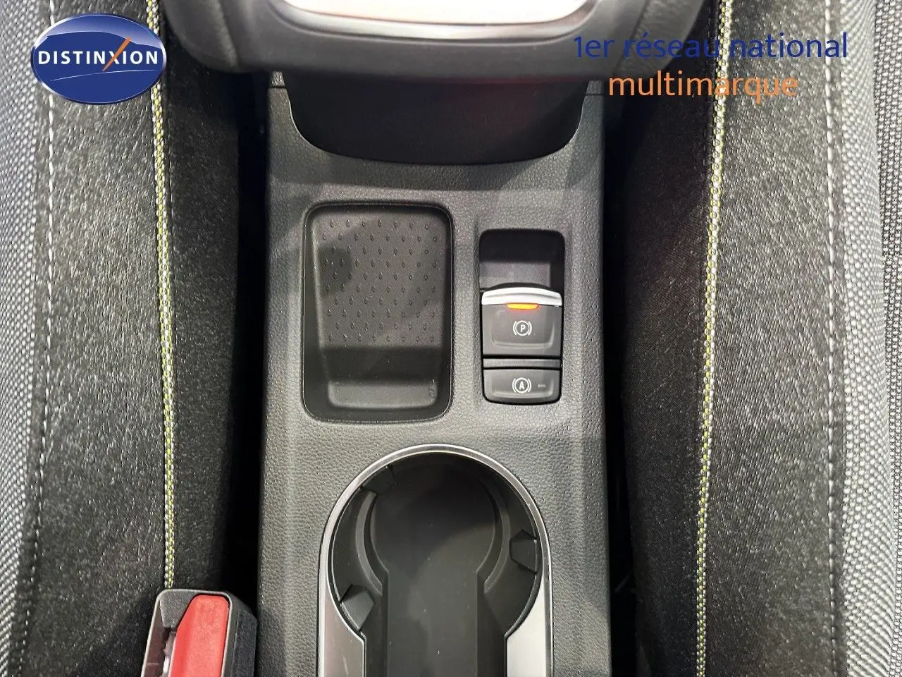 Vue plongeante sur la console centrale du Renault Captur 2025, gris cassiopée, avec porte-gobelet et commandes électroniques.
