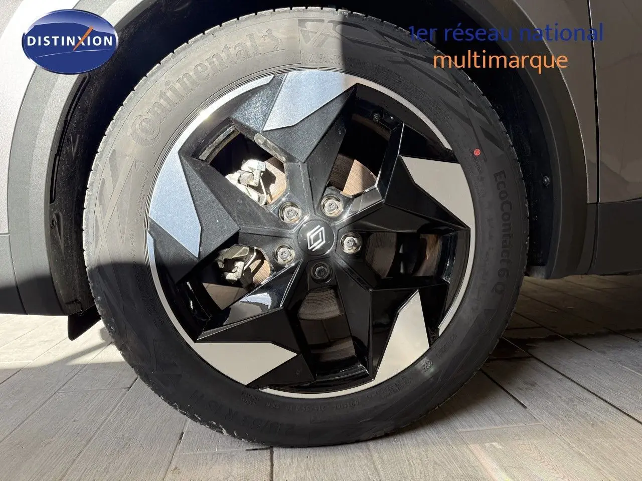 Gros plan sur la roue avant droite du Renault Captur gris Cassiopée Métal avec jante noire et argentée au design géométrique.