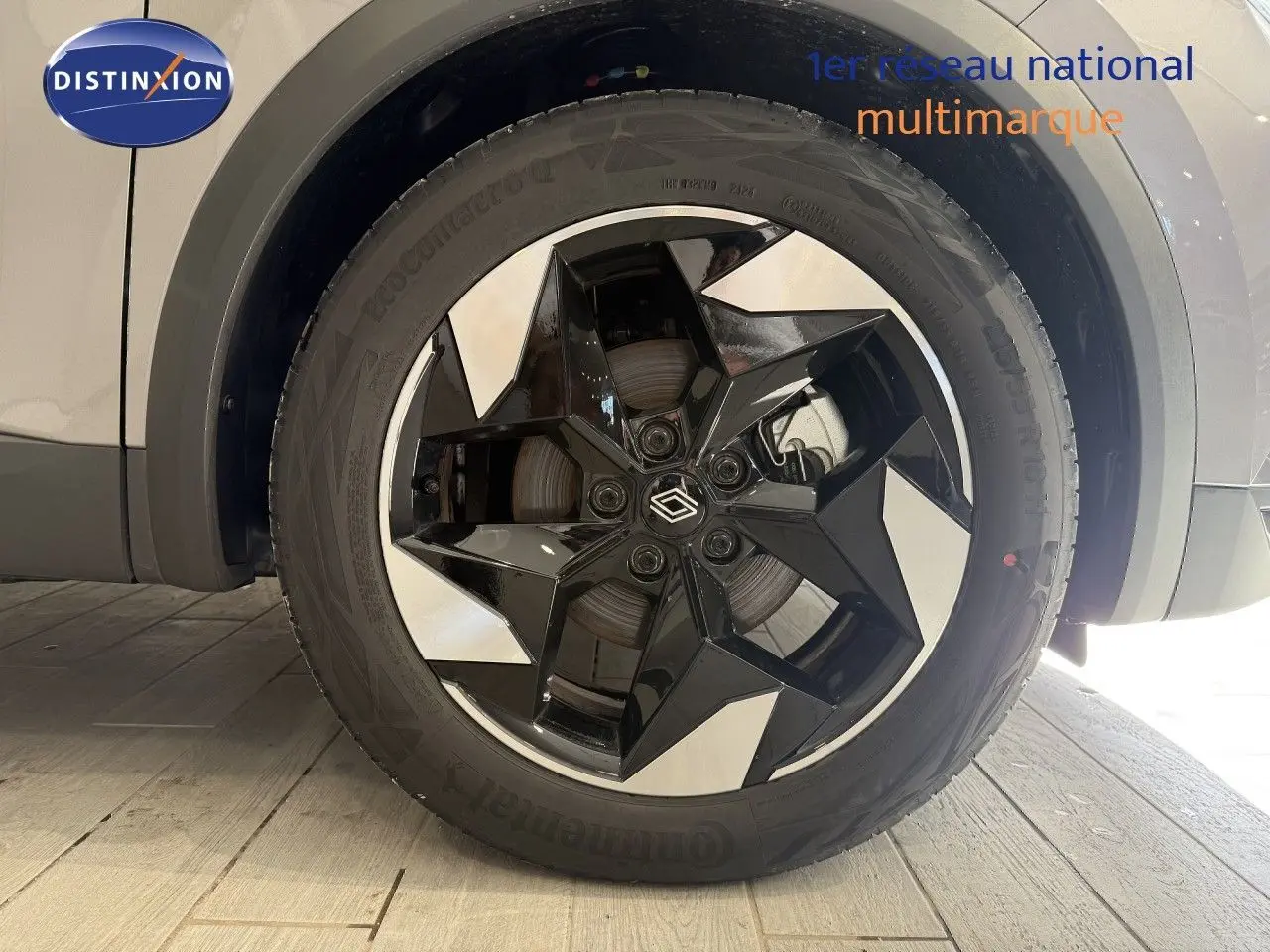 Gros plan sur la roue avant droite du Renault Captur gris Cassiopée Métal avec jante noire et argentée au design géométrique.