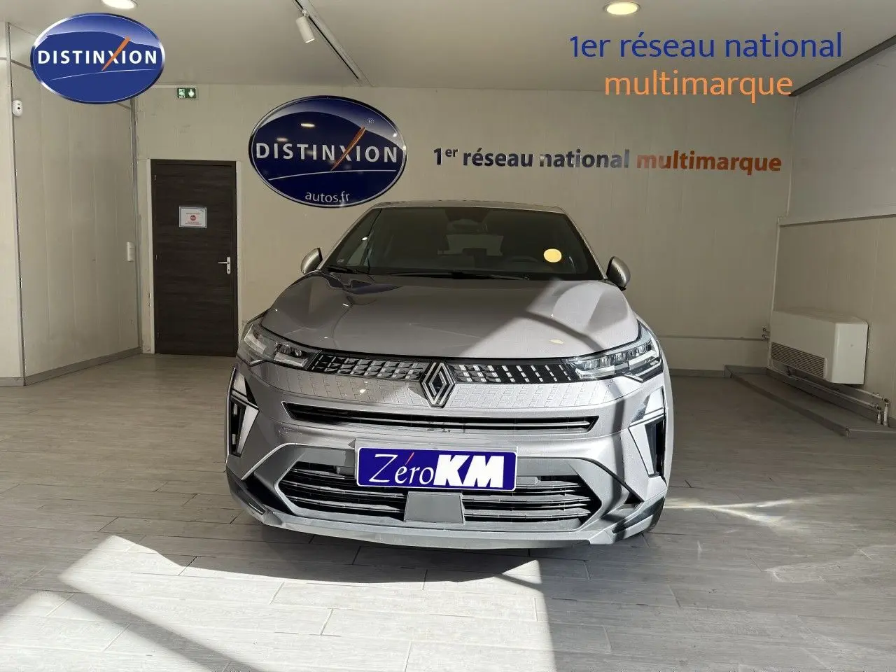 Vue avant d'un Renault Captur gris Cassiopée métal avec toit gris, en intérieur, soulignant sa calandre et ses phares LED.