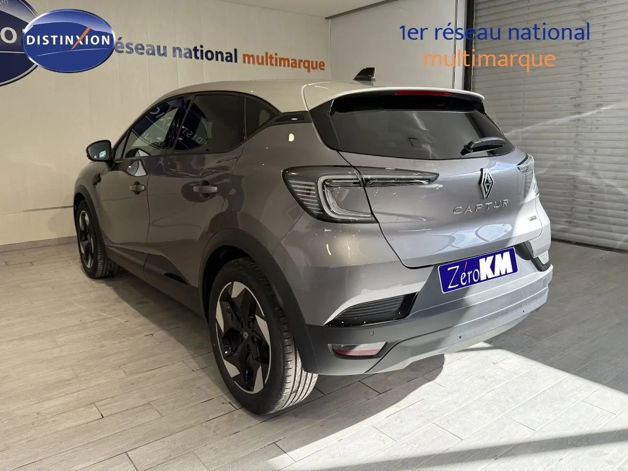 Vue 3/4 arrière droite du Renault Captur 2025 gris Cassiopée métal avec toit gris et jantes bi-ton.
