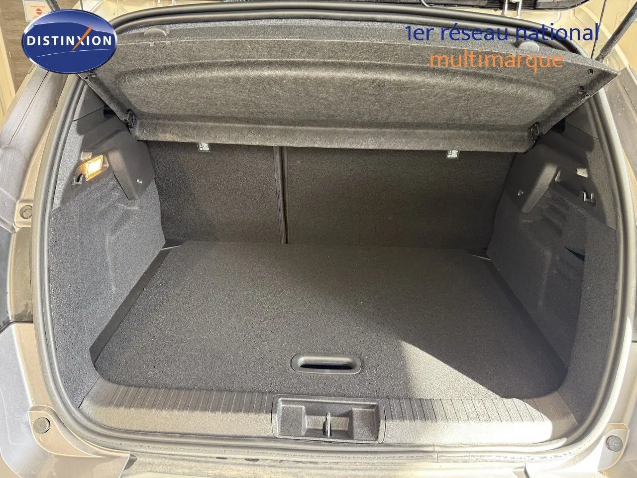 Coffre ouvert du Renault Captur gris Cassiopée métal avec intérieur noir, vue arrière montrant l'espace de chargement.