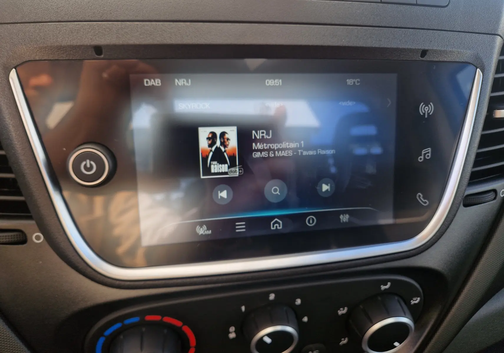 Écran tactile central du tableau de bord de l'Iveco Daily blanc, affichant la radio NRJ en mode DAB.