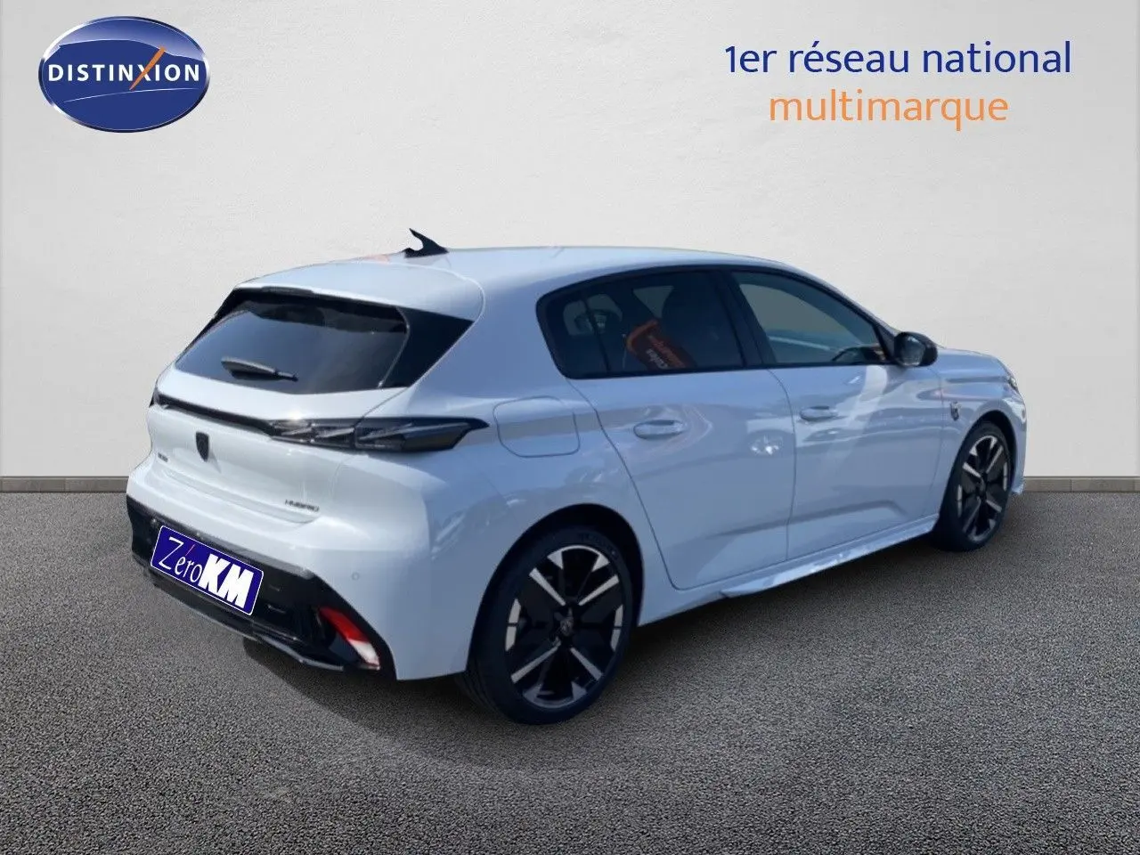 Vue 3/4 arrière droite d'une Peugeot 308 blanche Okenite Hybrid 145ch avec jantes noires et vitres teintées.