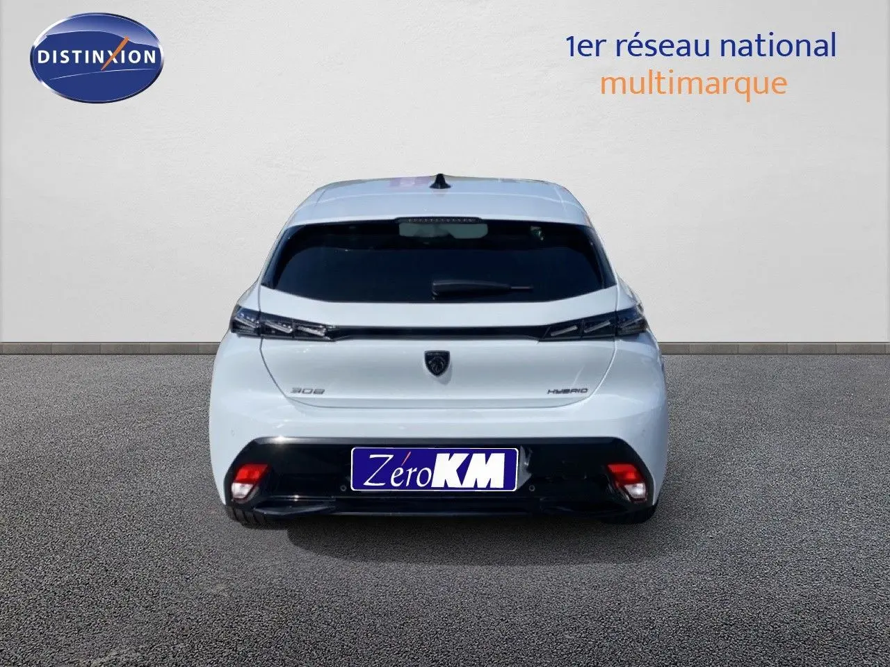 Vue arrière d'une Peugeot 308 blanche Okenite Metal, avec feux fins et logo noir central bien visibles.