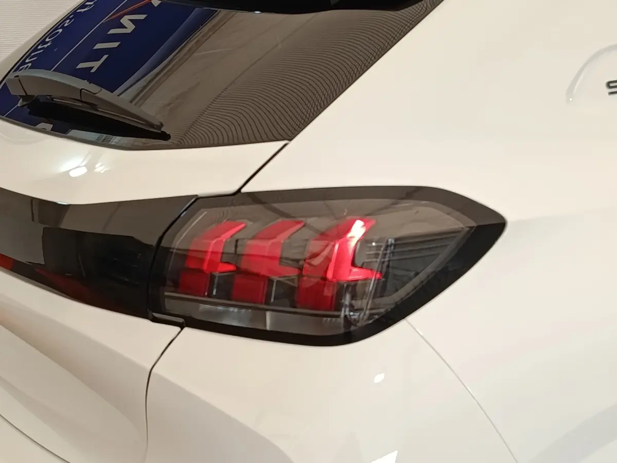 Feu arrière droit allumé d'une Peugeot 208 PureTech 75 S&S Style blanche vue en gros plan sur l'arrière.