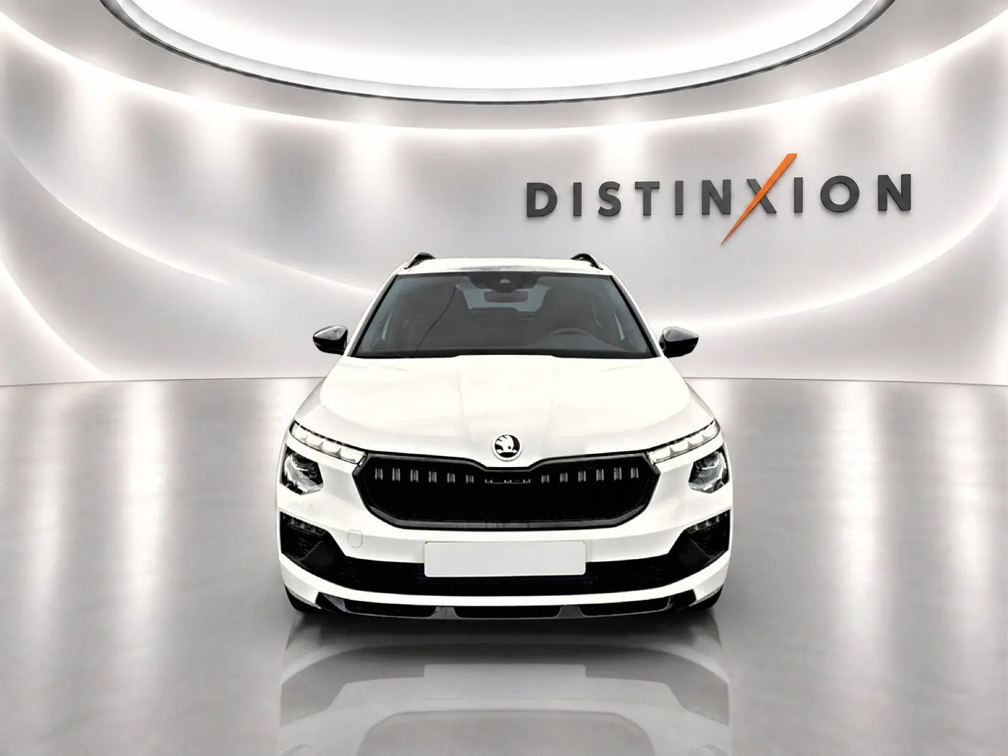 Vue avant d'un Skoda Kamiq blanc nacré dans un showroom avec logo Distinxion en arrière-plan.