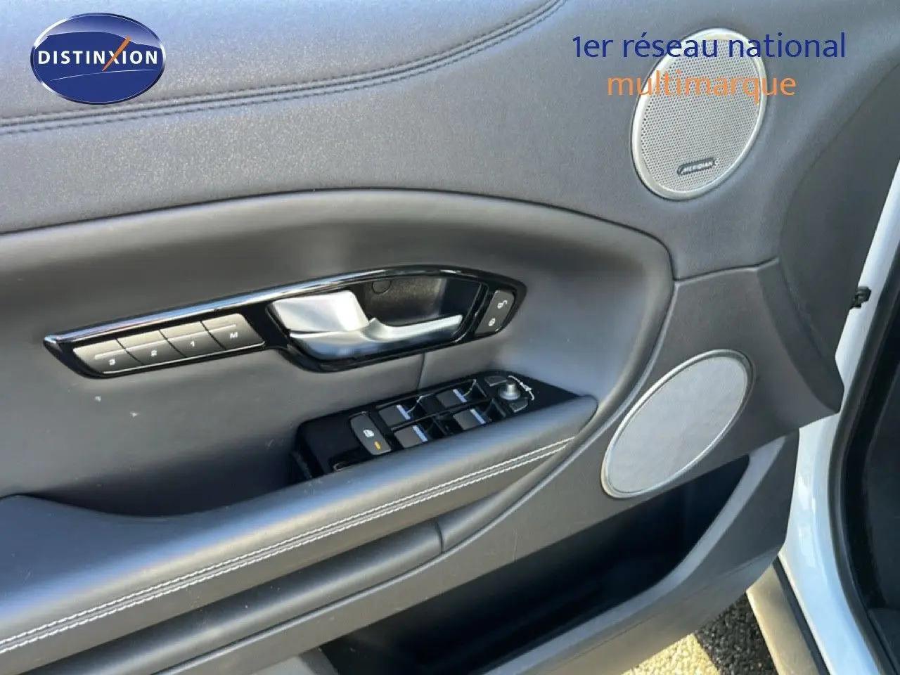 Gros plan sur la porte avant gauche blanche du Range Rover Evoque 2017, mettant en valeur les commandes et haut-parleurs intégrés.