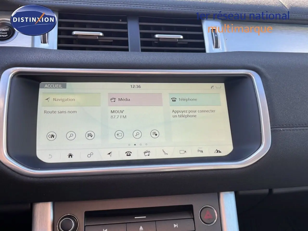 Écran tactile central du Range Rover Evoque blanc de 2017, affichant navigation, média et téléphone, tableau de bord noir.