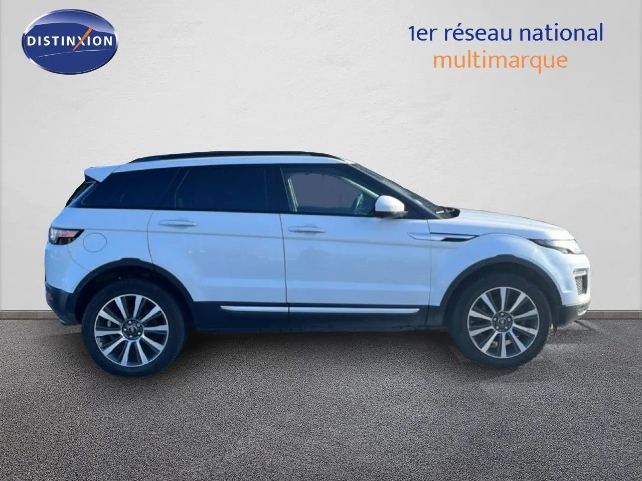 Profil côté gauche d'un Range Rover Evoque blanc 2017 avec toit noir et jantes alliage 19 pouces.