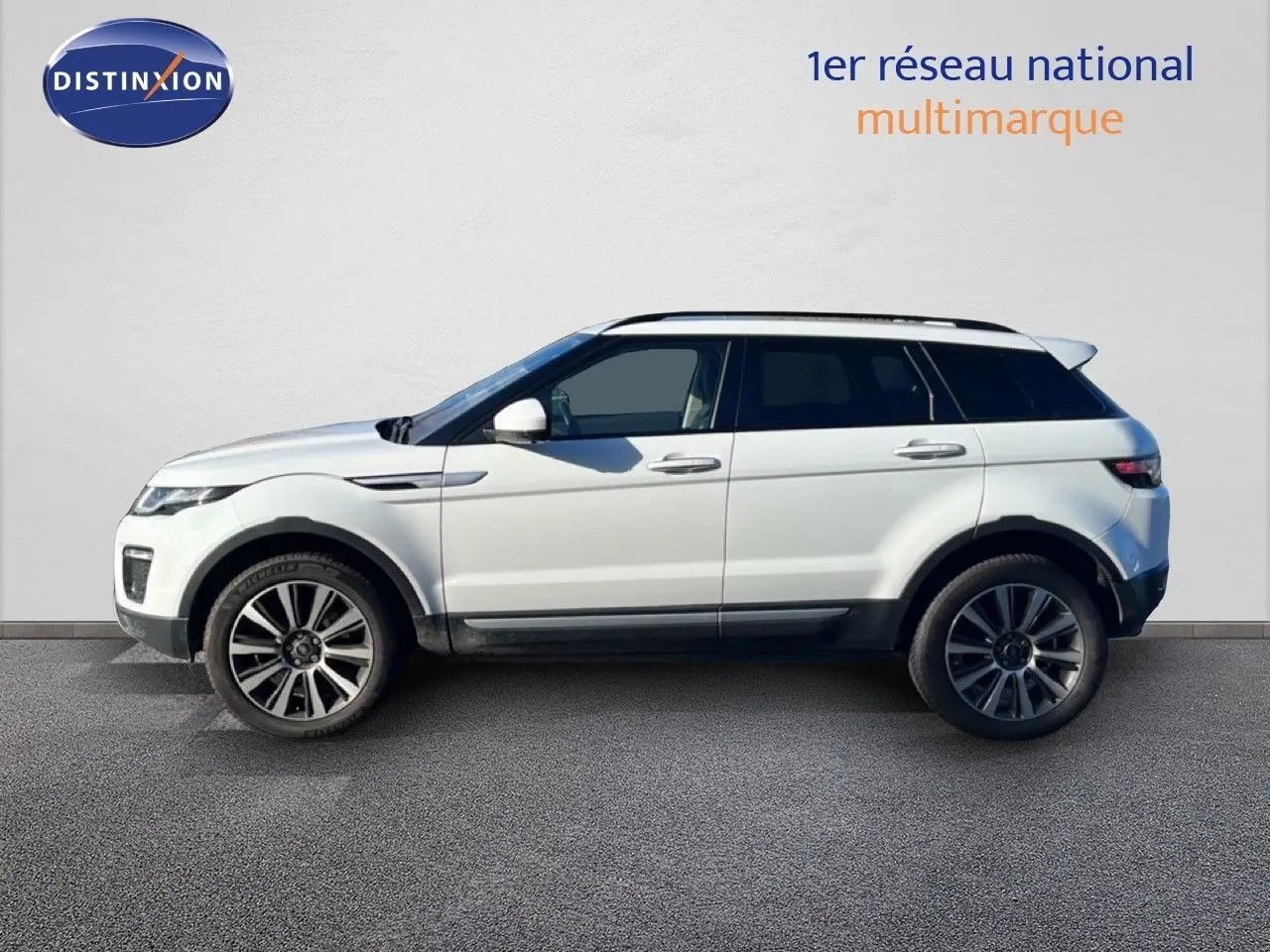 Profil latéral droit d'un Range Rover Evoque blanc de 2017 avec jantes alliage et toit panoramique noir.
