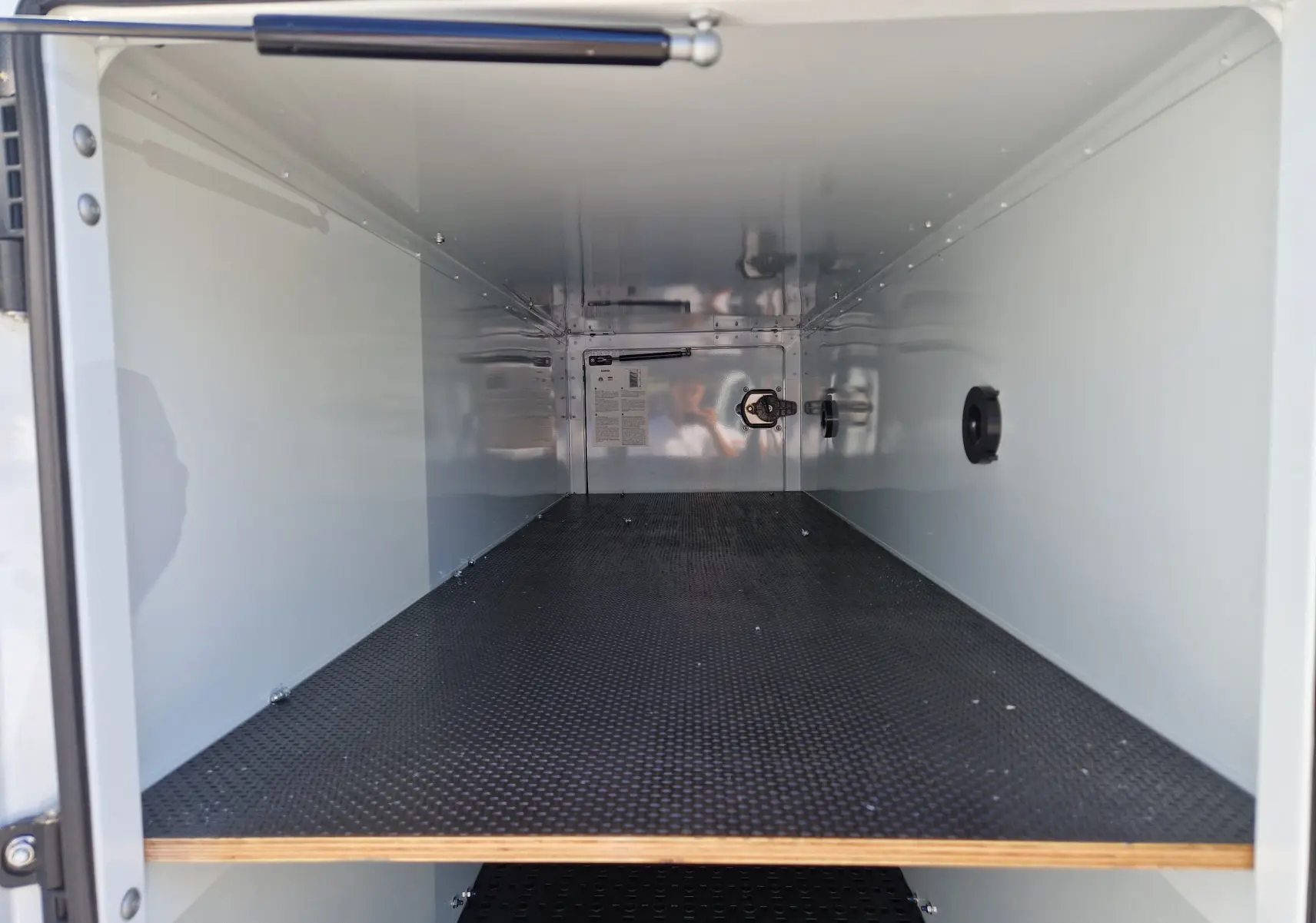 Vue intérieure du coffre blanc du fourgon Iveco Daily Chassis Cabine, montrant un espace de rangement propre et organisé.