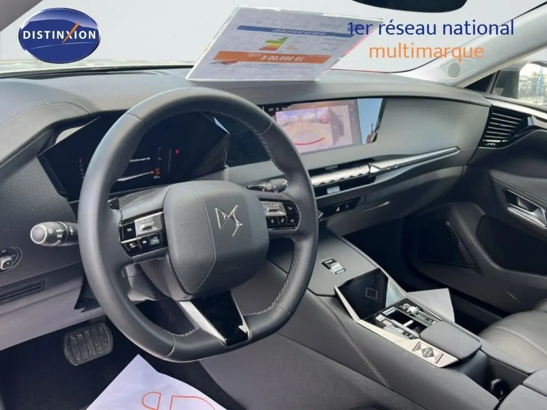 Vue intérieure de profil avant gauche du tableau de bord et volant cuir noir du DS4 2024 avec écran tactile et affichage tête haute.