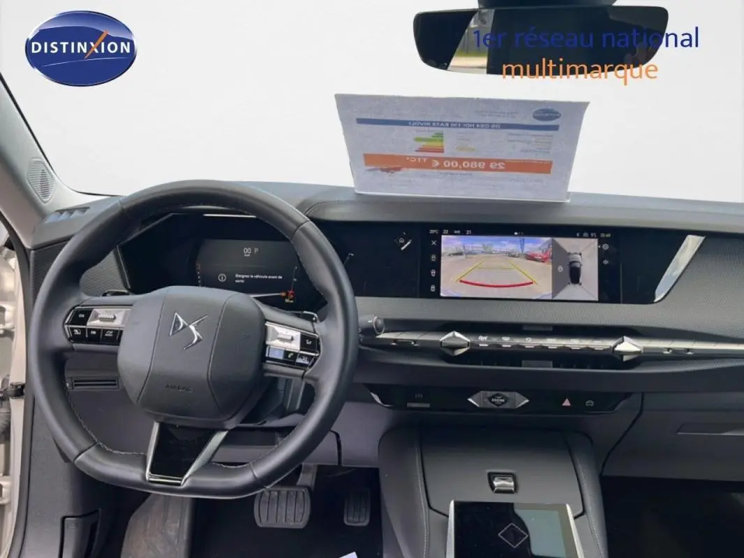 Vue intérieure frontale du tableau de bord noir de la DS4 2024 avec volant cuir et écran tactile affichant la caméra de recul.