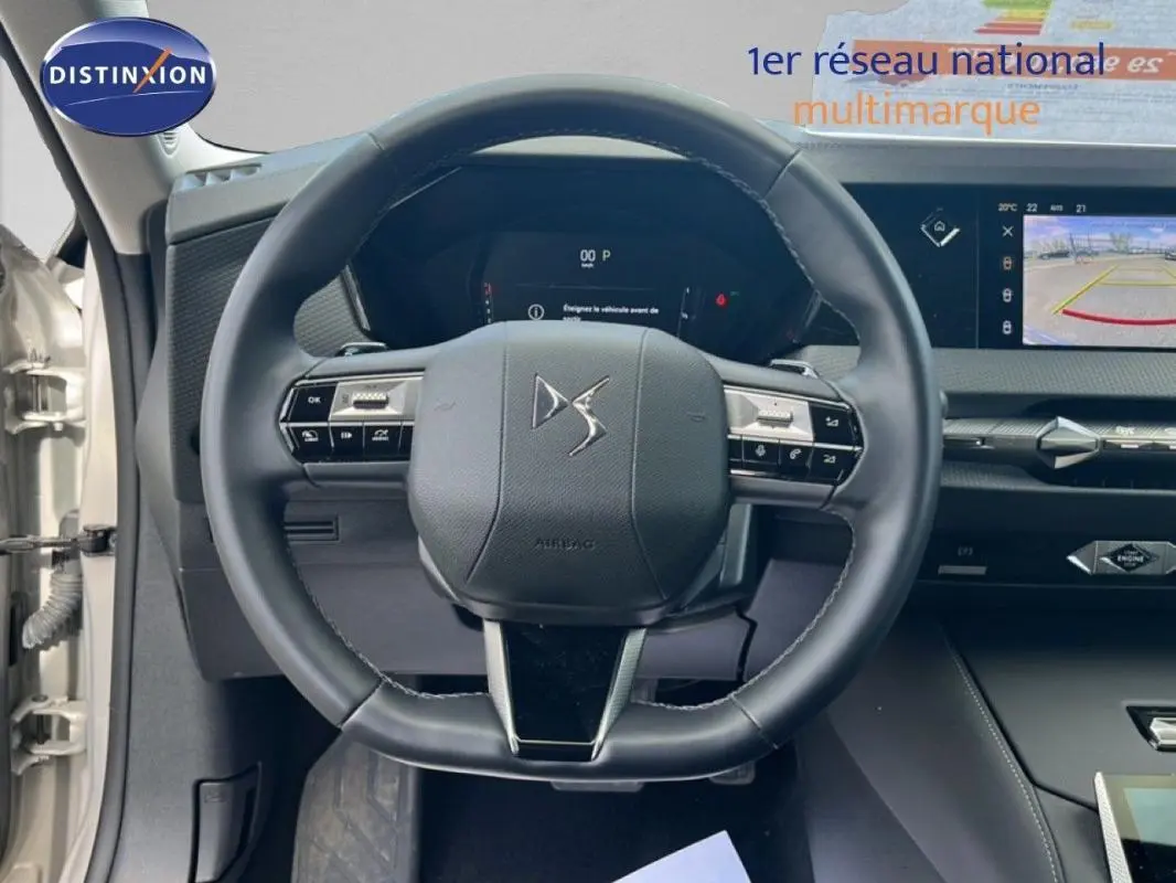 Vue intérieure centrée sur le volant cuir noir de la DS4 2024 avec tableau de bord digital et écran tactile.