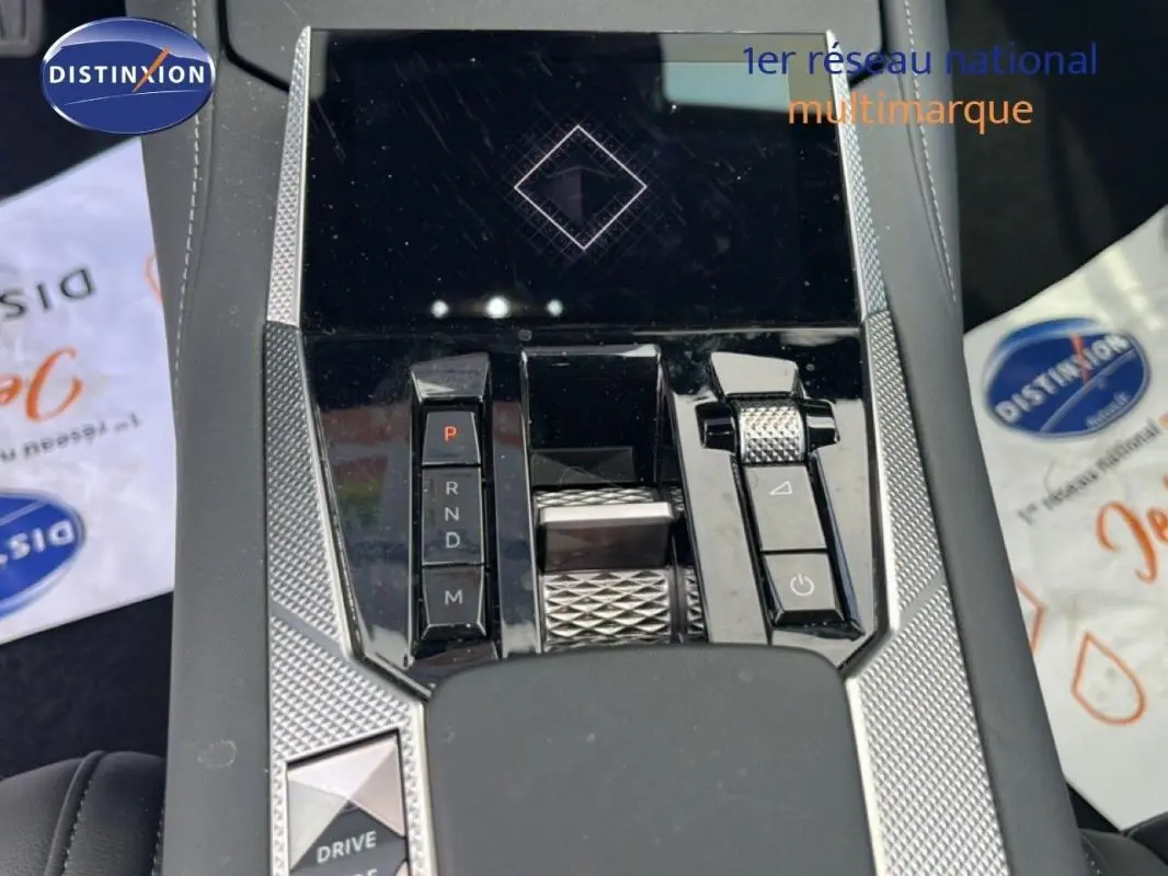 Vue plongeante sur la console centrale noire et argentée du DS4 2024 avec commandes de boîte auto et molette de réglage.