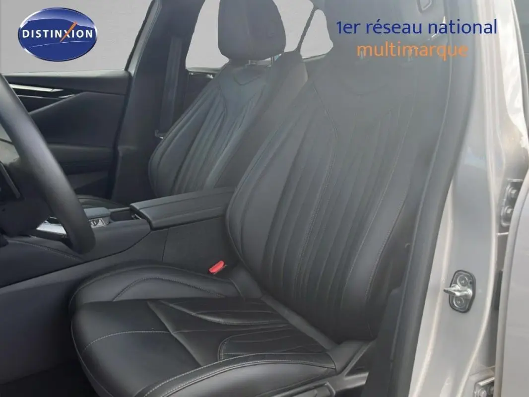 Vue intérieure côté conducteur du DS4 2024, sièges cuir noirs avec surpiqûres et accoudoir central.