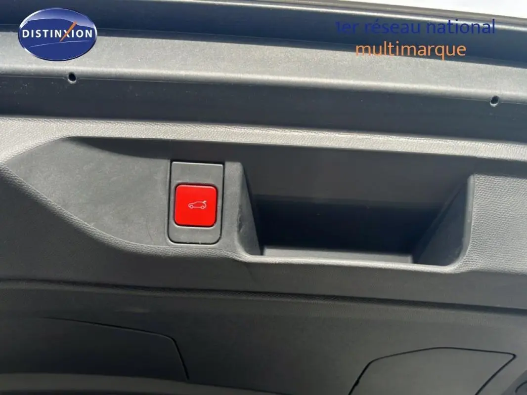 Gros plan sur le bouton rouge d'ouverture du coffre à l'intérieur du hayon d'une DS4 2024 gris foncé.