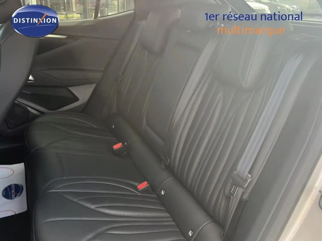 Vue latérale droite des sièges arrière en cuir noir de la DS4 2024, soulignant les finitions élégantes et les ceintures grises.