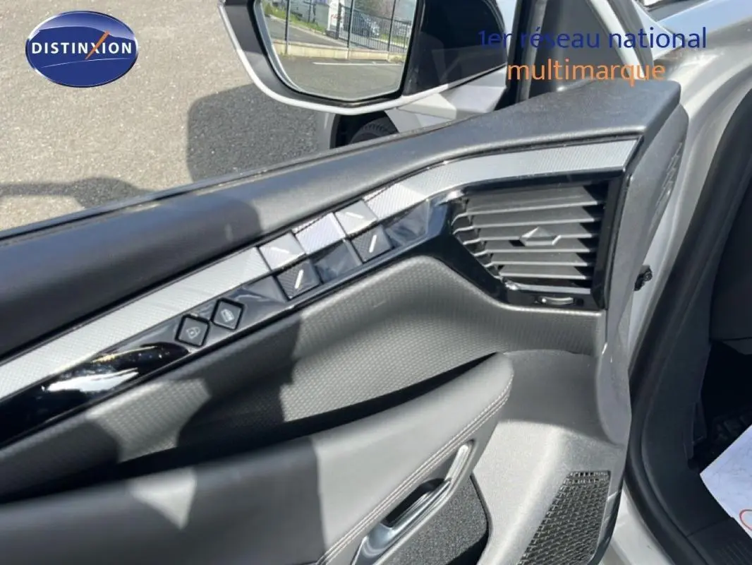 Vue rapprochée de la porte côté gauche de la DS4 2024 gris clair, avec commandes électriques et miroir extérieur.