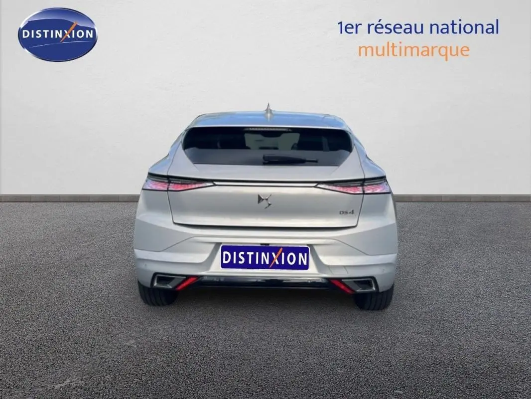 Vue arrière d'une DS4 2024 gris clair, avec feux étirés et double sortie d'échappement intégrée au pare-chocs.