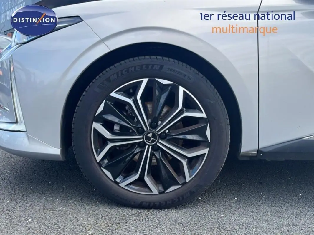 Gros plan sur la roue avant gauche avec jante noire et argentée du DS4 gris clair 2024.