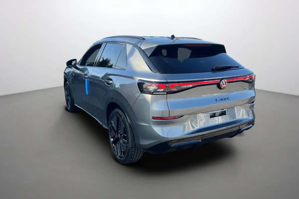 Vue 3/4 arrière droite du Volkswagen T-Roc gris loup avec feux arrière LED et vitres surteintées.