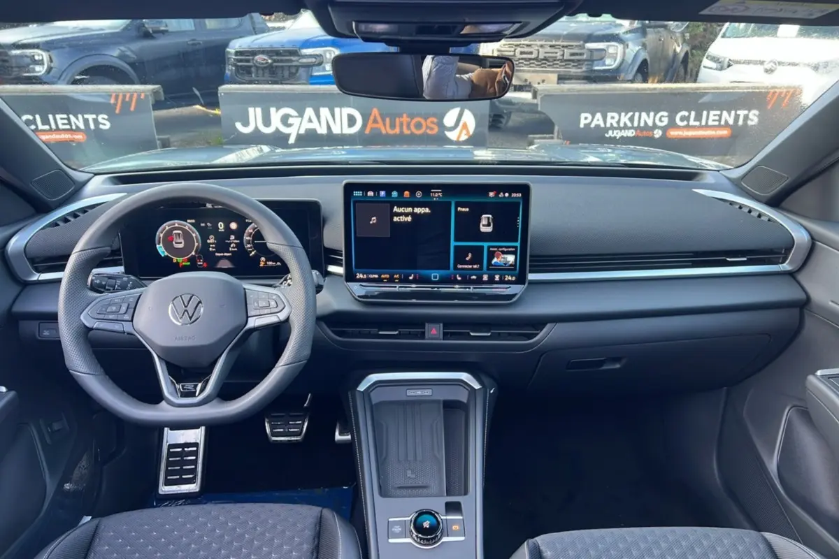 Vue intérieure avant du Volkswagen T-Roc 2026, tableau de bord moderne avec écran tactile central et volant multifonctions cuir.