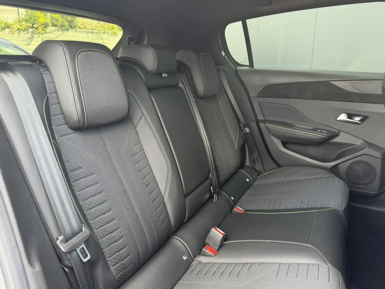 Vue latérale droite de la banquette arrière noire et tissu avec surpiqûres vert Adamite du Peugeot 308 NV Hybrid 145 GT.