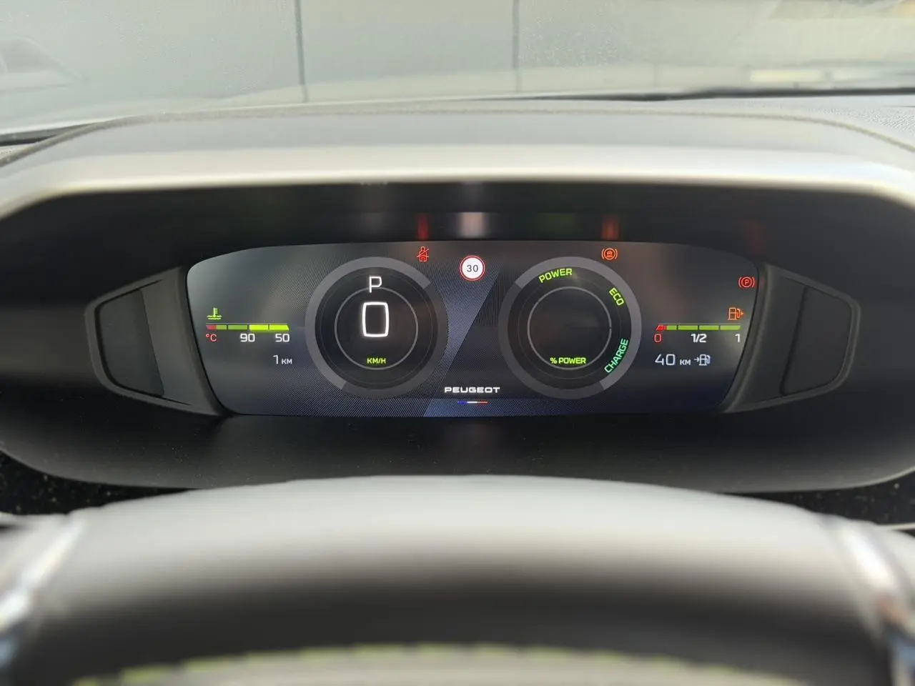 Vue rapprochée du combiné numérique 10'' du Peugeot 308 gris Selenium, affichant la vitesse et l’état hybride.