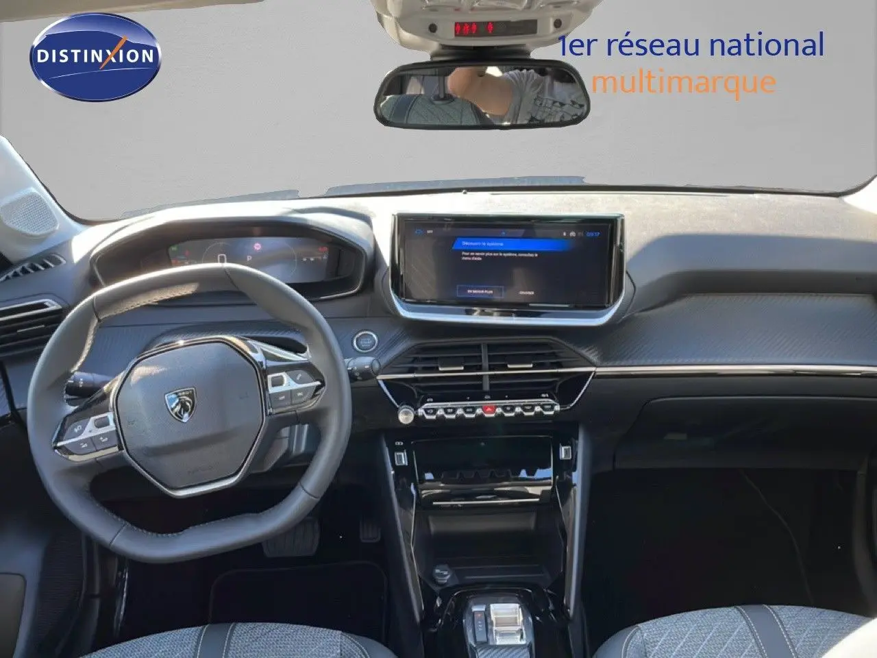 Vue intérieure frontale du tableau de bord et volant noir de la Peugeot 208 Hybrid 110ch Allure 2026 avec écran tactile central.