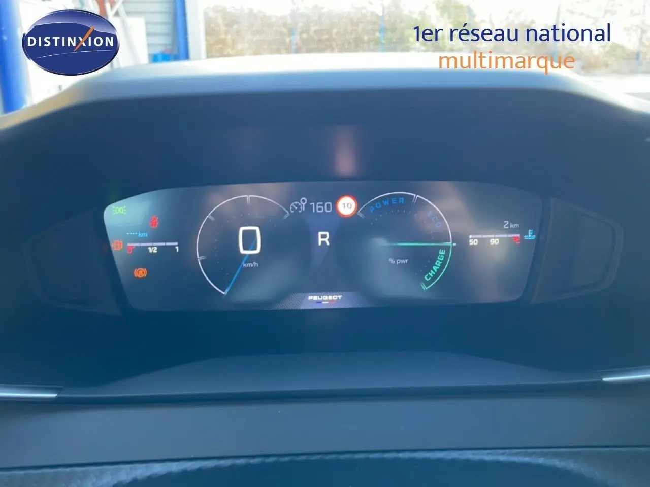 Tableau de bord numérique de la Peugeot 208 Hybrid 110ch, affichage clair avec indicateurs de vitesse et charge.