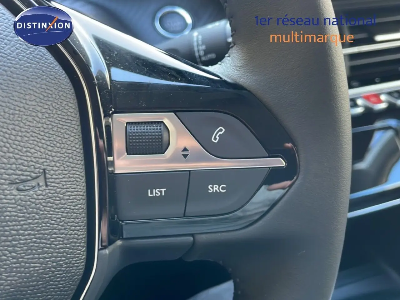 Gros plan sur les commandes gauche du volant noir de la Peugeot 208 Hybrid 110ch Allure, intérieur moderne et épuré.