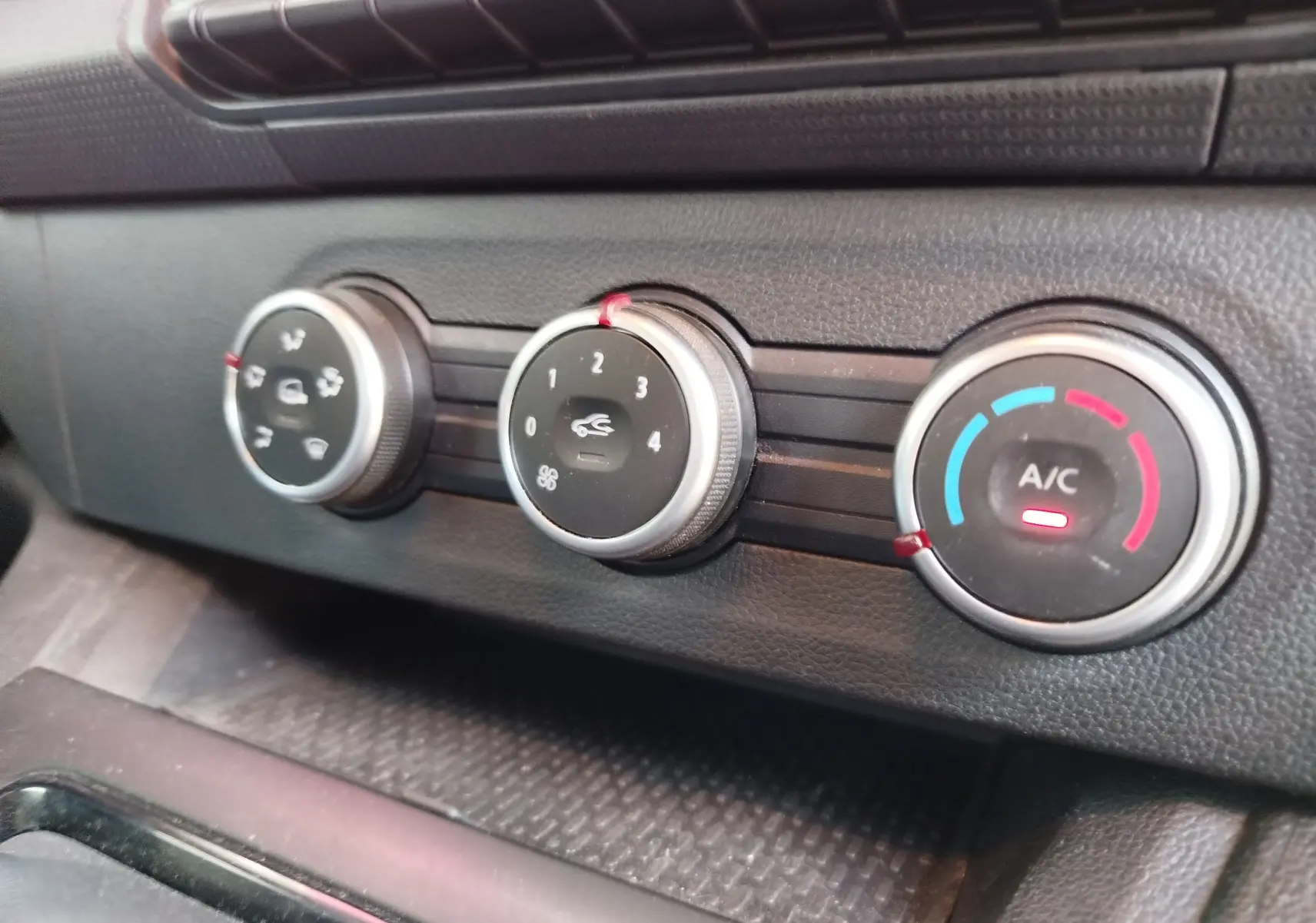 Gros plan sur les commandes de climatisation du Renault Kangoo 2023, avec réglages manuels et indicateur A/C allumé.