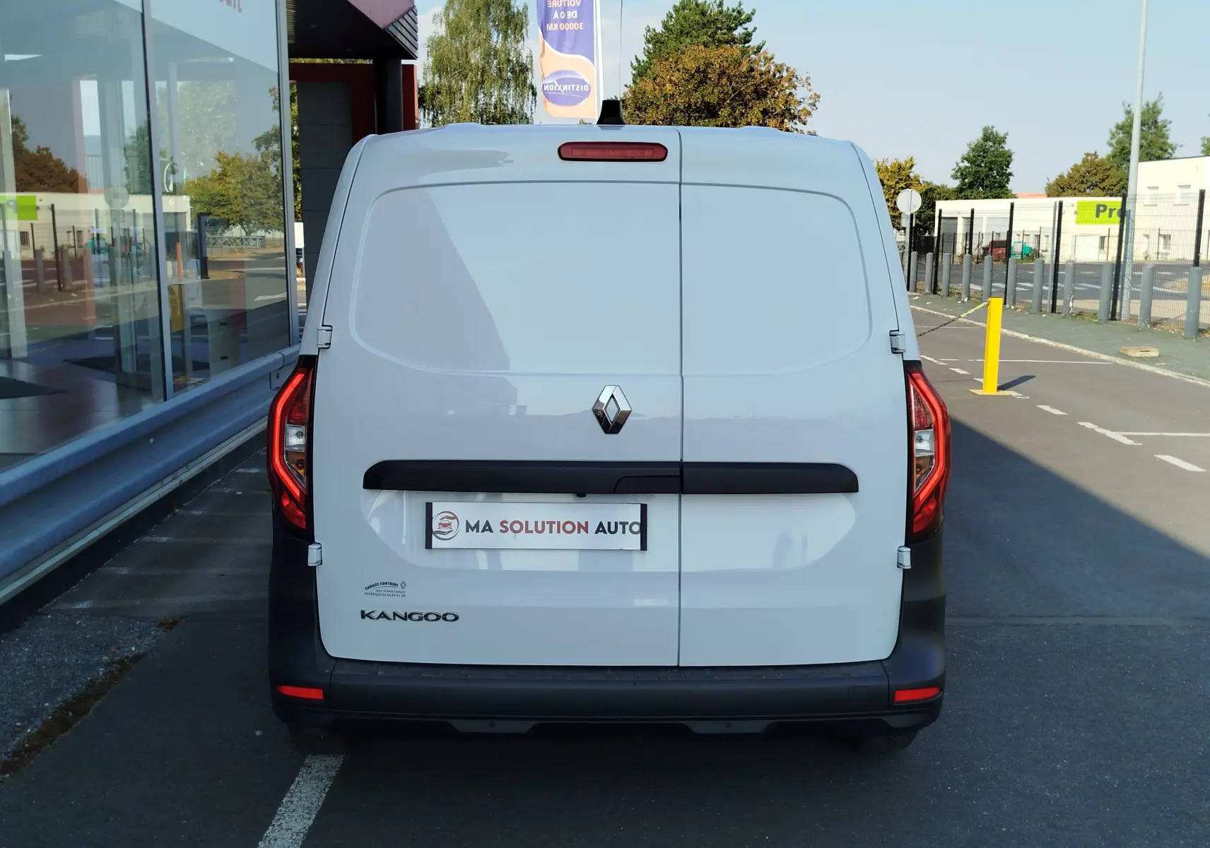 Vue arrière d'un Renault Kangoo blanc minéral 2023, avec portes battantes fermées et feux arrière allongés rouges.