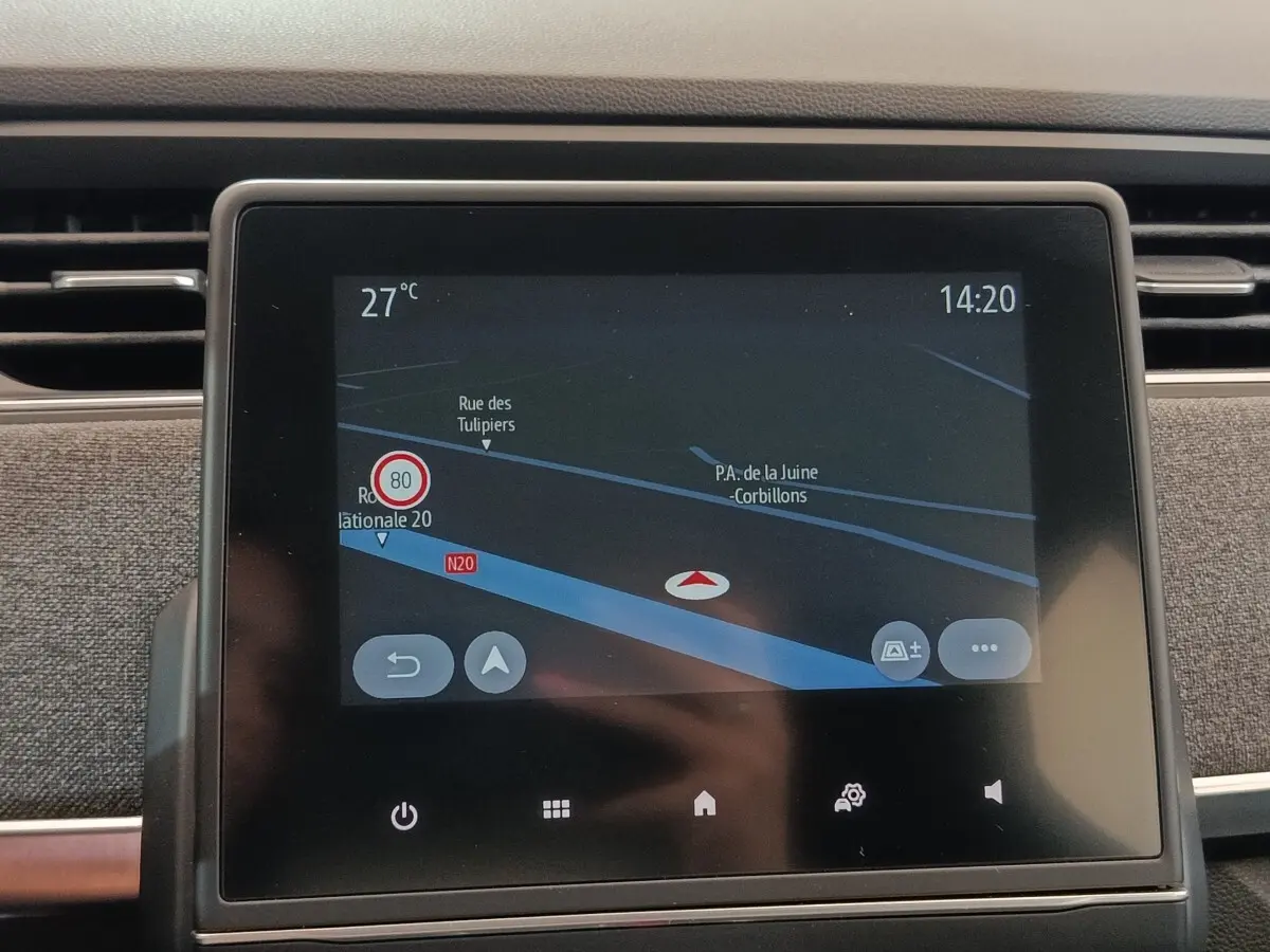 Écran tactile central du tableau de bord Renault ZOE blanc, affichant la navigation GPS en intérieur.