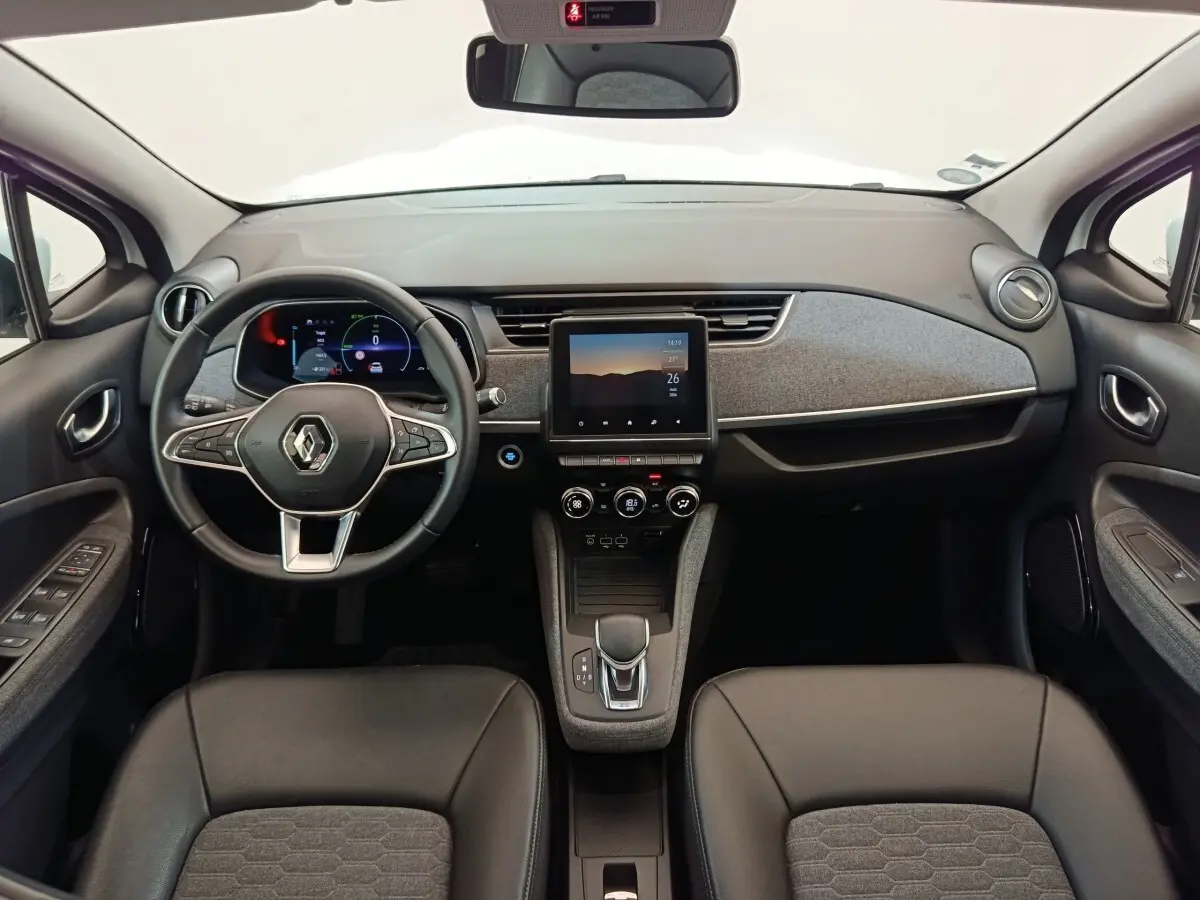 Vue intérieure frontale du tableau de bord de la Renault ZOE Intens R110 avec écran tactile central et volant multifonction.