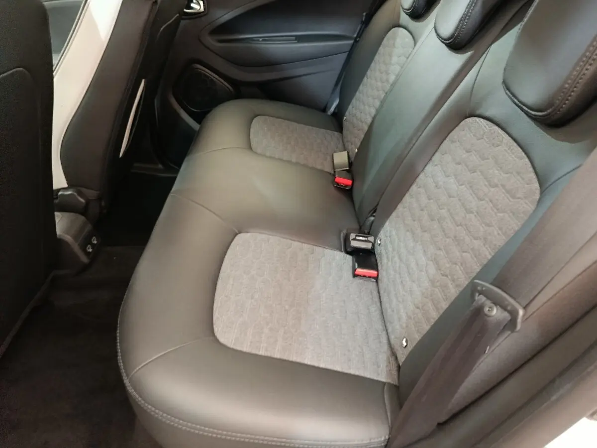 Vue intérieure du siège arrière droit de la Renault ZOE Intens blanc, avec assise bicolore cuir et tissu gris.