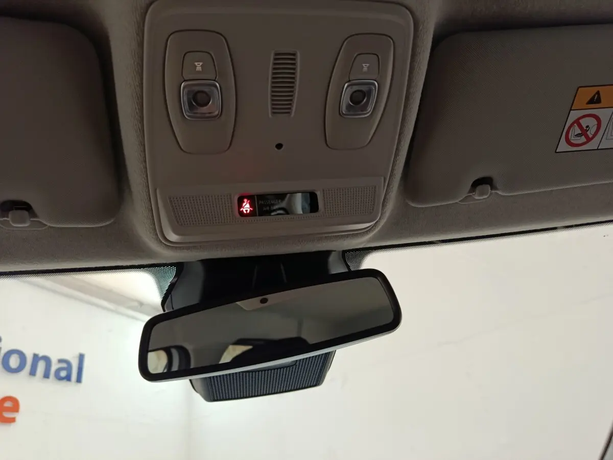 Vue intérieure du rétroviseur central et du plafonnier beige avec éclairages et témoin d'airbag passager allumé.