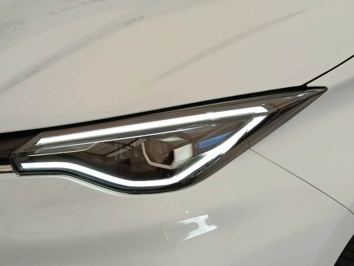 Gros plan sur le phare avant droit LED de la Renault ZOE Intens R110 blanc, soulignant son design moderne et élégant.