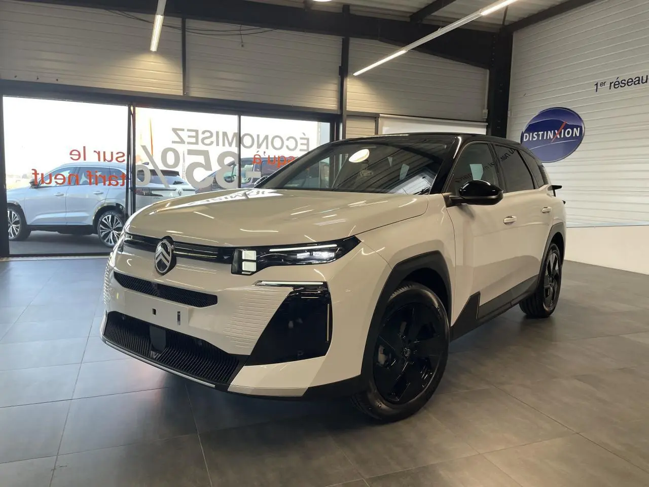 Citroën C5 Aircross blanc Okenite vue 3/4 avant en intérieur avec toit noir et jantes noires brillantes.